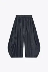 Pantalón ancho de denim azul oscuro, tiro medio, con cintura elástica ajustable mediante cordones interiores y pierna muy ancha con volumen que termina en un ruedo redondeado.