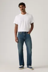 Jeans de mezclilla azul con lavado medio, corte de pierna recta y tiro medio. Presenta cinco bolsillos, cierre frontal con botones y trabillas para cinturón.