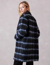 Tapado símil mohair, marca Dictionary, con estampado a cuadros en negro y azul. Tiene cuello con solapa, cierre frontal con botones y bolsillos delanteros. Incluye forro interno a tono.