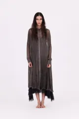 Vestido camisero largo, color gris oscuro con efecto desgastado/lavado. Presenta cuello camisero, botones frontales y mangas largas. El bajo es irregular y se superpone con un forro o capa de tela negra con terminación de encaje o volado.