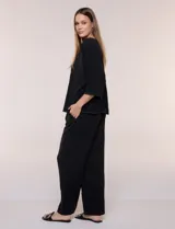 Pantalón pull-on de color beige con caída fluida, cintura elastizada fruncida, bolsillos laterales funcionales y pierna amplia de corte wide leg.
