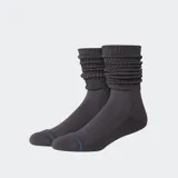 Medias de caña media con diseño slouch, confeccionadas en tejido gris con textura acanalada en la parte superior y detalle de logo bordado.