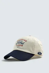 Gorra de seis paneles, color beige, con visera azul marino. Presenta bordado frontal con el texto "Genuine Ford Parts" en tonos azul y rojo, y un pequeño parche bordado con el logo de Ford en el lateral.
