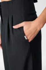 Pantalón de tiro alto con corte holgado y pierna ancha. Presenta bolsillos laterales ocultos en la costura y una faja desmontable ajustable en la cintura.