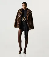 Campera corta de pelo sintético con estampado animal print de leopardo. Presenta un diseño estructurado con cuello amplio y solapas, ideal para un look sofisticado.