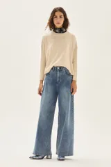 Sweater de tejido de punto color crudo, con escote redondo y mangas largas con puños acanalados. Presenta un calce cómodo y holgado.