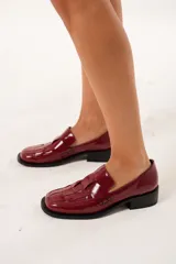 Mocasín de cuero charol color cereza con diseño enrejillado en la capellada, horma cuadrada, plataforma delantera y taco bajo.