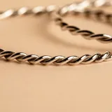 Esclava rígida de diseño trenzado, confeccionada en plata 925 con acabado brillante.