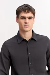Camisa de manga larga color beige, de tejido texturado con cierre frontal de botones y cuello camisero clásico.