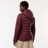 Campera ligera acolchada tipo puffer, color bordó, con capucha integrada, cierre frontal y diseño de costuras horizontales.