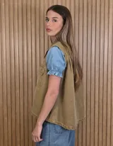 Chaleco de denim 100% algodón en color negro gastado, con cuello camisero, cierre frontal de botones metálicos y bolsillos delanteros con solapa.