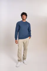Buzo de cuello redondo en color azul, con diseño liso y logo bordado pequeño en el pecho. Presenta puños y ruedo acanalados.