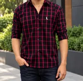 Camisa de manga larga con diseño de cuadros en color negro y rojo, confeccionada en 100% algodón, con cuello clásico y cierre frontal de botones.