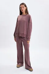 Pantalon deportivo de corte ancho y tiro medio, con efecto lavado en color marrón. Presenta aberturas laterales en el ruedo y cintura elástica con cordón de ajuste.