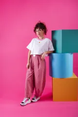 Pantalón de corte holgado y estilo japonés, color rosa, confeccionado en poliéster. Presenta cintura elástica con un aplique decorativo de acrílico en el frente y bolsillos laterales.