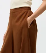 Pantalón de sastrería modelo aladim color marrón, con cintura recta, piernas amplias y ruedo ajustado. Confeccionado en tejido fluido de viscosa y poliéster.