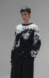 Sweater de punto con diseño abstracto tipo tie-dye o manchado en tonos gris y negro, de cuello redondo, manga larga y corte oversize. Presenta terminaciones en punto rib en cuello, puños y ruedo.