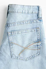 Jean baggy de tiro bajo en denim de algodón rígido, con piernas amplias y diseño de cinco bolsillos.