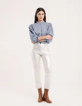 Pantalón negro estilo jeanero confeccionado en gabardina elastizada con terminación metalizada, pierna recta con largo por arriba del tobillo, cierre delantero y botón.