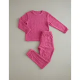 Pijama de dos piezas de tejido plush texturado con diseño de puntos en relieve, compuesto por un buzo de manga larga con cuello redondo y un pantalón largo de corte recto.
