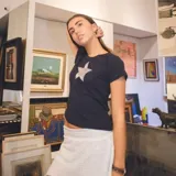 Remera negra de algodón de manga corta con aplique de estrella roja en el pecho.