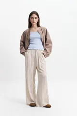 Campera verde militar sin cuello, con elástico y cinto regulable en la cintura, bolsillos amplios y cierre frontal.