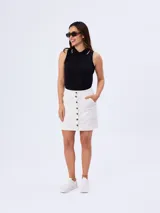 Falda corta de jean blanca con botonera frontal central y bolsillos laterales.
