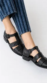 Sandalias tipo cangrejera de cuero color marrón, con diseño de tiras cruzadas y textura en la parte frontal. Cuentan con pulsera al tobillo con hebilla metálica y taco bajo.