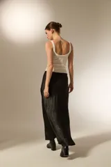 Falda midi evasé de poliéster color negro con textura sutil.