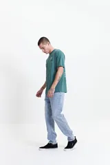 Pantalón jean gris de corte slim, tiro medio y con presillas para cinturón.