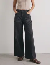 Jean wide leg de tiro alto color negro con efecto lavado, corte recto amplio y detalle de encaje en los laterales.