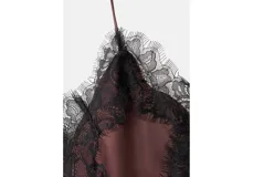 Top lencero de satén color bordó con escote en V y detalles de puntilla negra en el borde superior y lateral. Presenta un diseño asimétrico con tirantes finos ajustables.