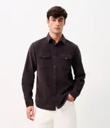 Camisa de hombre de corte regular confeccionada en terciopelo de algodón, con cuello clásico, cierre frontal de botones y dos bolsillos con solapa en el pecho.