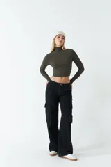 Polera de manga larga ajustada al cuerpo, confeccionada en tejido rib de algodón. Presenta cuello alto y diseño corto tipo crop top.
