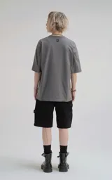 Remera de corte holgado y diseño minimalista, con cuello redondo y mangas cortas de hombros caídos. Confeccionada en algodón premium, presenta un largo a la altura de la cadera.