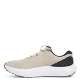 Championes de running Under Armour modelo Charged Surge 4, color beige con detalles en negro y suela blanca. Confeccionados en malla transpirable con refuerzos sintéticos laterales para mayor soporte y entresuela con tecnología Charged Cushioning para una amortiguación reactiva.