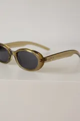 Lentes de sol con armazón ovalado de color negro y cristales tonalidad marrón. Presentan un detalle metálico en forma de estrella en las patillas.