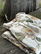 Bombacha de algodón con estampado floral en tonos tierra y verdes sobre fondo crudo. Presenta un detalle de botón en la cintura.