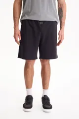 Bermuda deportiva sin friza color negro, con cintura elastizada y cordón ajustable. Corte semi baggy y suelto.