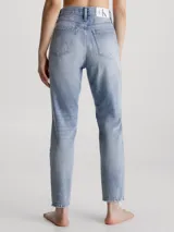 Pantalón de jean celeste claro, de corte mom, con roturas en las rodillas y ruedo desflecado.