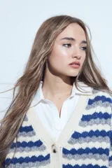 Cardigan de tejido de punto con diseño de rayas horizontales en tonos azul, gris y crema. Presenta escote en V, cierre frontal con botones grandes y mangas largas con puños anchos acanalados.
