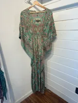 Kaftan largo con estampado floral en tonos turquesa y fucsia, con detalles de guarda pampa en los bordes.