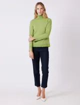 Polera de tejido fino, color rosado, con cuello alto, manga larga y detalle de tajo en los puños.