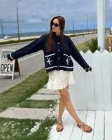 Cárdigan de tejido punto color azul marino, con diseño náutico bordado en la espalda que incluye un velero rojo y blanco, olas blancas y la inscripción "le port" en blanco.