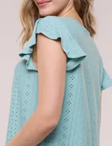 Blusa blanca de broderie con escote redondo, canesú en V con detalle de encaje, frunces en el frente y mangas cortas tipo mariposa.