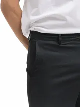 Bermuda de lino color azul marino, de corte recto y largo a la rodilla. Presenta bolsillos laterales y cierre frontal.