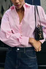 Camisa de algodón con estampado de rayas verticales en color rosado y blanco, cuello solapa y manga larga.