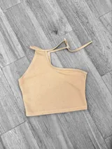 Top blanco irregular con un solo bretel y espalda descubierta.