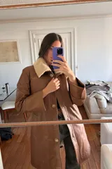 Tapado largo de cuero ovino color caramelo con cuello de piel sintética desmontable, detalles de pasamanería a tono en hombros y espalda y botones de guampa.