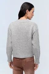 Sweater gris jaspeado de tejido de punto con mangas largas con aberturas.